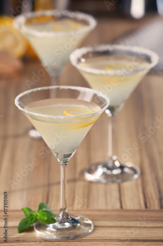 Glasses with tasty lemon drop martini cocktail on table