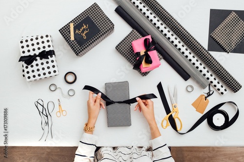 Woman Decorating Presents with a Black Bow photo