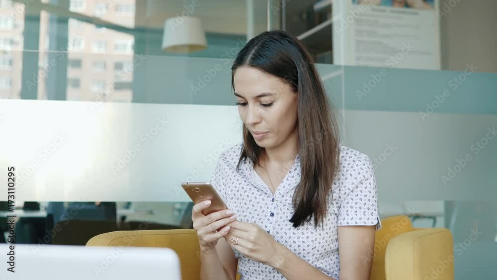 Young smiling woman holding a smartphone in hand and surfing in Internet. People stock footage slider shot. Young smiling woman holding a smartphone in hand and surfing in Internet. People stock footage slider shot.