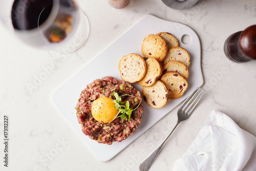 Top-view of steak tartare with yolk and crackers