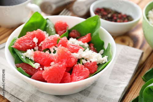Plate of salad with spinach, grapefruit and cottage cheese on table