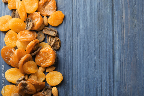 Dried apricots and nuts on wooden background