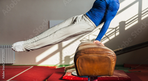 Male gymnast performing on pommel horse