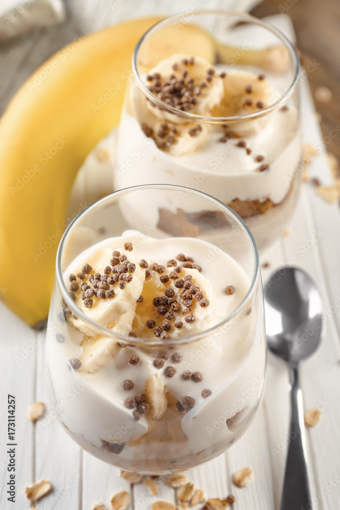 Glasses with yummy banana pudding on wooden board Glasses with yummy banana pudding on wooden board