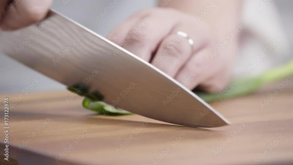Chef dices green onions on cutting board, close up Chef dices green onions on cutting board, close up