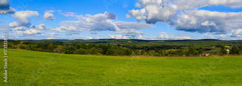 Hudson Valley skyline with farm land and meadows on a cloud filled summer day.