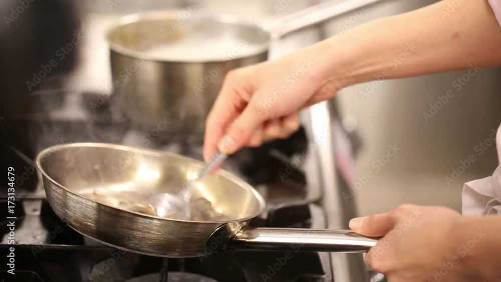 Chef sautes exotic food in pan, close up Chef sautes exotic food in pan, close up