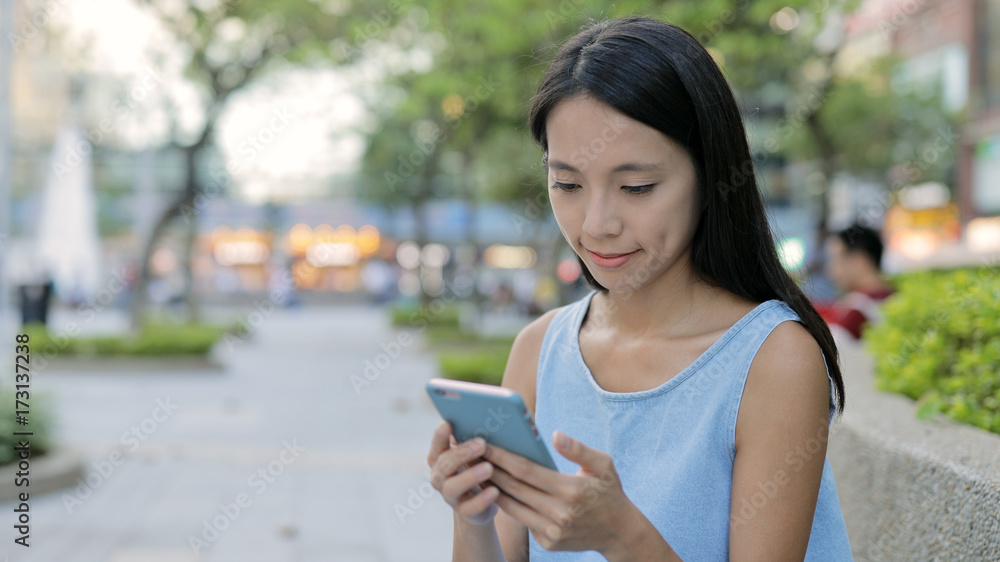 Young Woman sending sms on cellphone in city Young Woman sending sms on cellphone in city