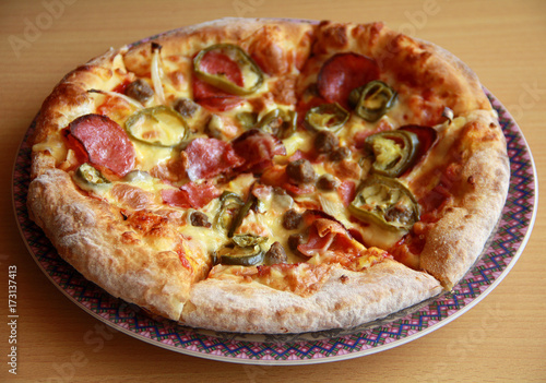 Pizza with topping Smoked Beef, Onion, Green Pepper, and Mozzarella Cheese. Wood background.