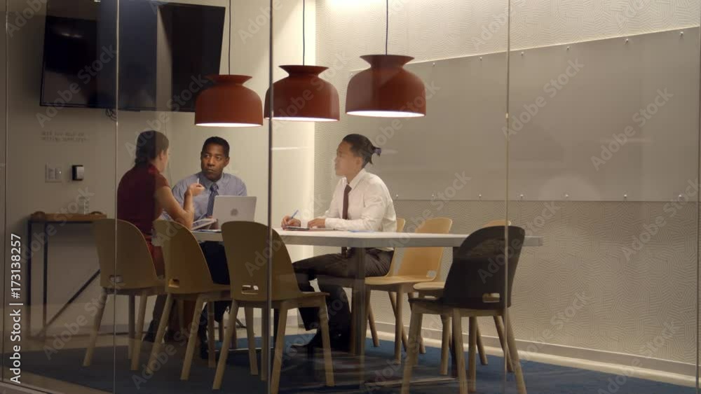 Colleagues in meeting cubicle at a big corporate business Colleagues in meeting cubicle at a big corporate business