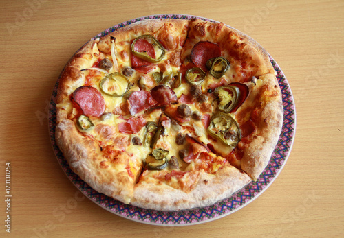 Pizza with topping Smoked Beef, Onion, Green Pepper, and Mozzarella Cheese. Wood background.