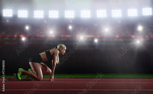 woman  sprinter leaving starting blocks photo