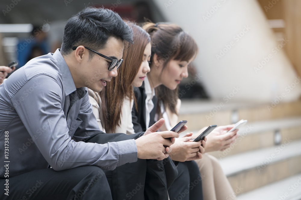 Close up of businessmen and businesswomen using smartphone, business communication concept