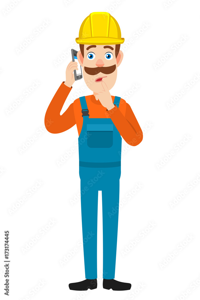 Builder talking on mobile phone and standing with his finger to his lips Builder talking on mobile phone and standing with his finger to his lips