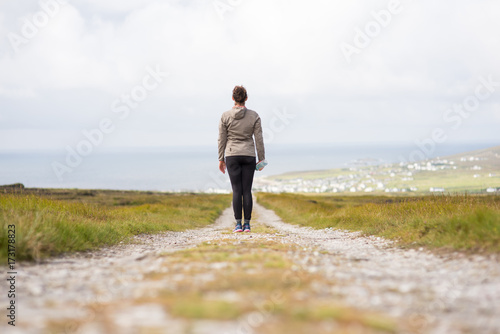 Young woman on a walkway back facing standing