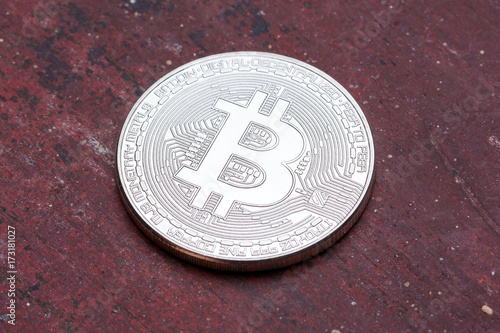 Red background with silver bitcoin on it. photo