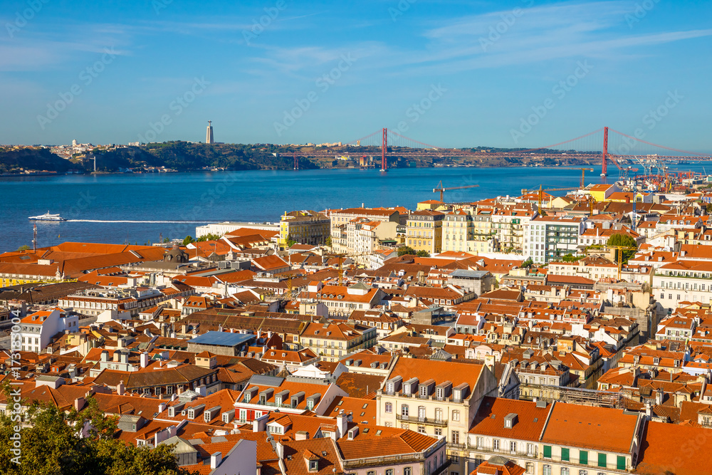 Lisbon aerial view from popular Sao Jorge Castle, Portugal, Europe. Bridge of 25 April, Cristo Rei, Alfama District and Tagus River on background. Panoramic view over center of Lisbon in a sunny day