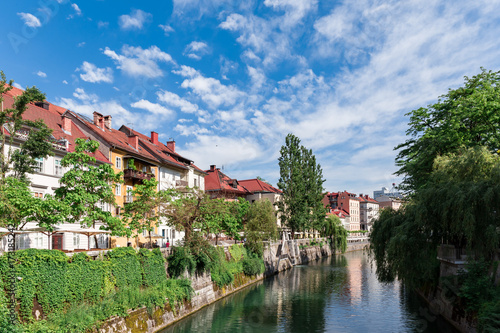 Riverbank of the Ljubljanica in Ljubljana Europe colorful river embankment green trees and red roof houses 