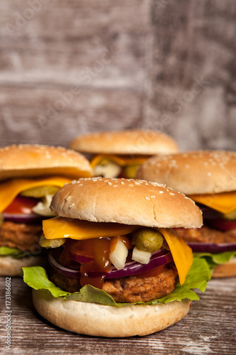 Gourmet tasty burgers on wooden background. Fast and tasty food