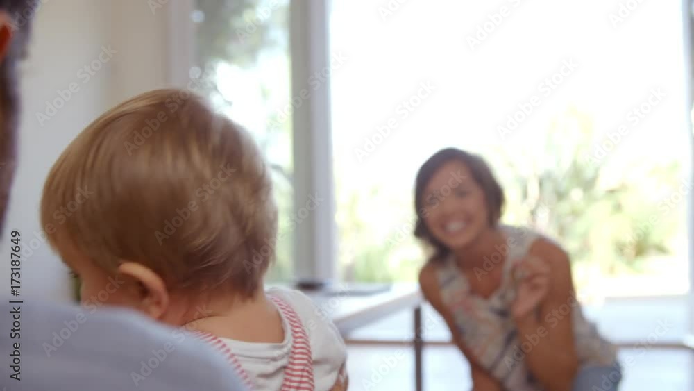 Parents Watching Baby Son Take First Steps At Home Parents Watching Baby Son Take First Steps At Home