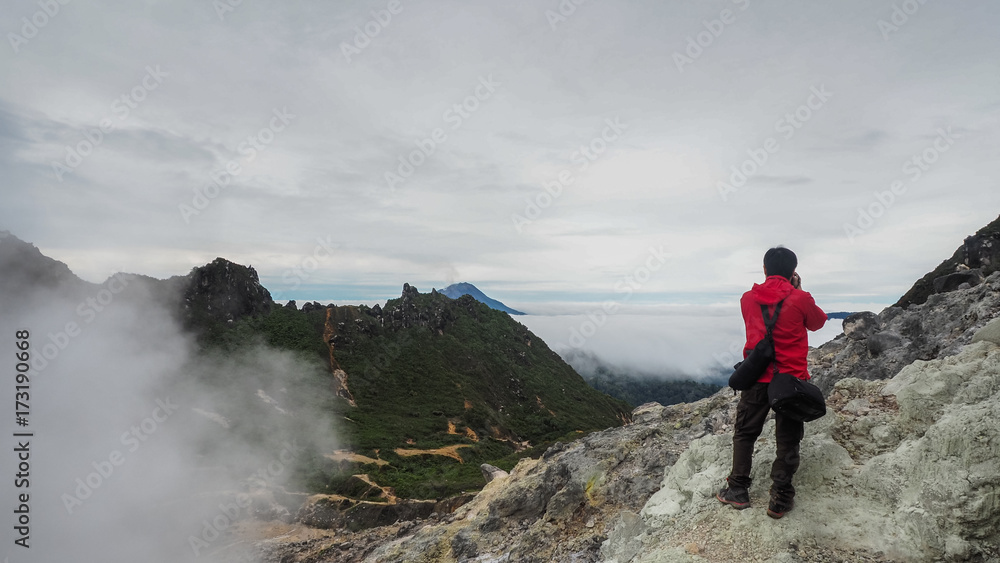 Freedom man standing on top of Mount Sibayak, Indonesia