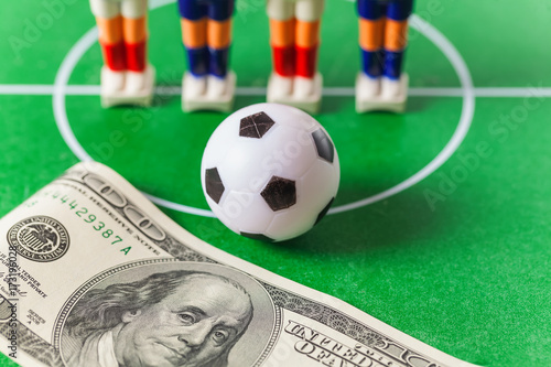 Table football .soccer players ball and dollars on the field.bookmaker concept