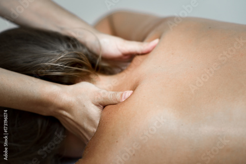 Foto Young woman receiving a back massage in a spa center.