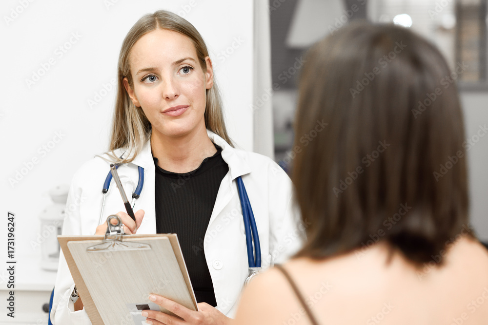 Female doctor explaining diagnosis to her young woman patient. Female doctor explaining diagnosis to her young woman patient.