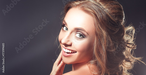 Beautiful woman with curly long hair on dark background