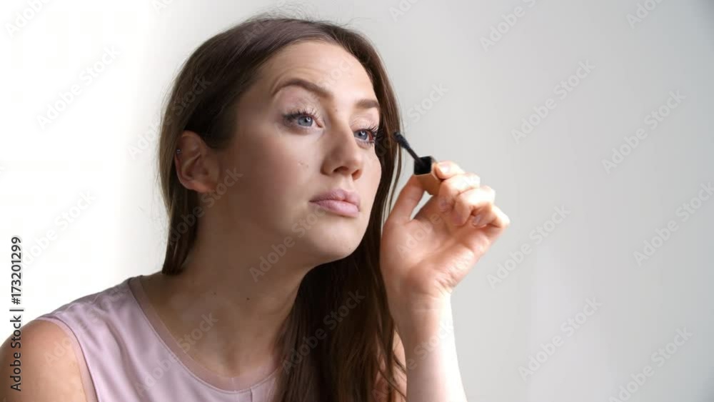Studio Shot Of Attractive Woman Putting On Mascara Studio Shot Of Attractive Woman Putting On Mascara