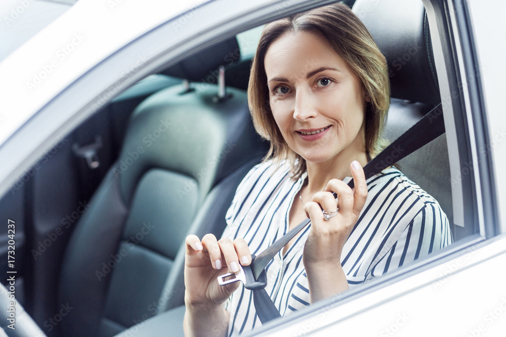 Road safety concept. Pretty business woman fastening her seat belt in a car Road safety concept. Pretty business woman fastening her seat belt in a car