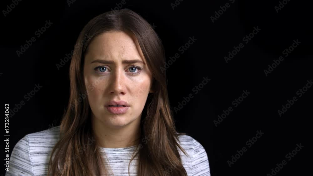Studio Shot Of Scared Young Woman Flinching From Abuse Studio Shot Of Scared Young Woman Flinching From Abuse