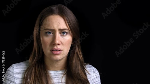 Studio Shot Of Scared Young Woman Flinching From Abuse photo