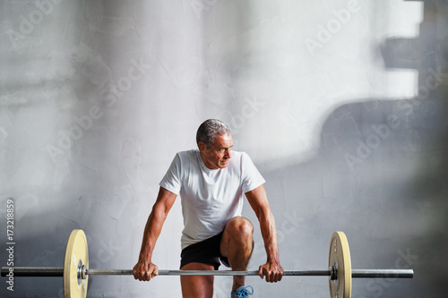 Принти на полотні Senior man preparing to do a weight workout at the gym