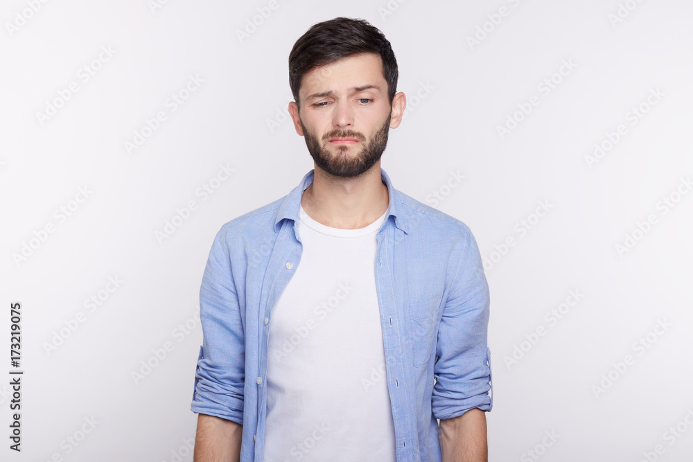 Unhappy and sad Caucasian student grimacing, displeased with his failure on exams. Young dissatisfied employe disappointed with results of examination interview. Human face expressions and emotions. Unhappy and sad Caucasian student grimacing, displeased with his failure on exams. Young dissatisfied employe disappointed with results of examination interview. Human face expressions and emotions.