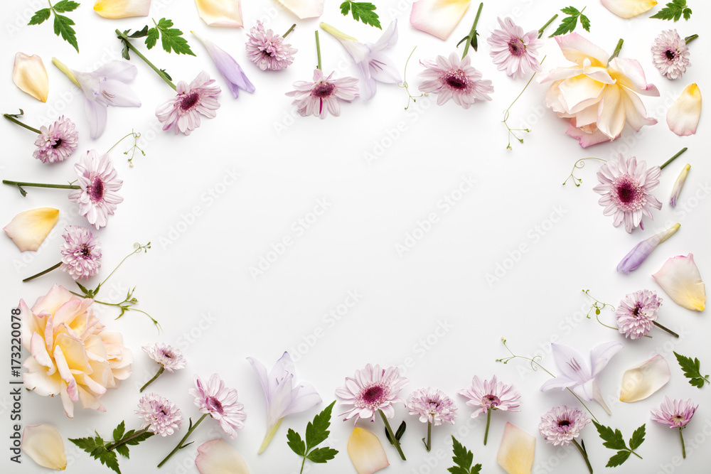 Frame made of flowers and leaves on white background. Flat lay, top view.