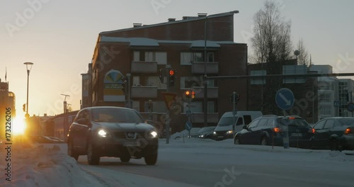 Wallpaper Mural ROVANIEMI, FINLAND - JANUARY 06, 2017: Scene of winter town at sunset. Car traffic on snowy roads and vehicles making a stop on red traffic lights Torontodigital.ca