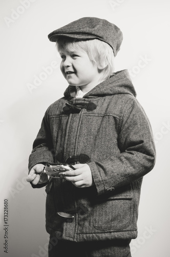 Φωτογραφία Portrait of young child holding photography camera on light background