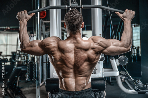 Handsome model young man training back in gym © antondotsenko