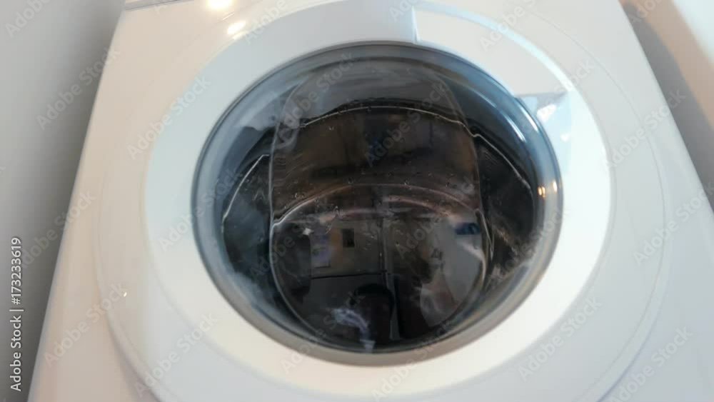 Washing machine washes laundry such as color clothing in front view Washing machine washes laundry such as color clothing in front view