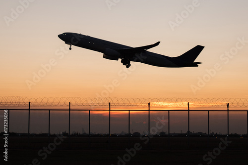 Silhouette takeoff plane from the airport while sunset