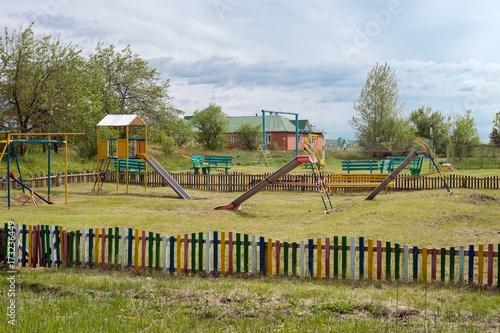 Детская площадка с горками в сельской местности.
