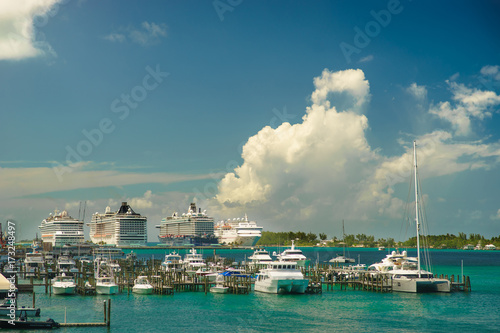 Four giant cruise ships in a row at Nassau port with a lot of yachts foreground. Bahamas