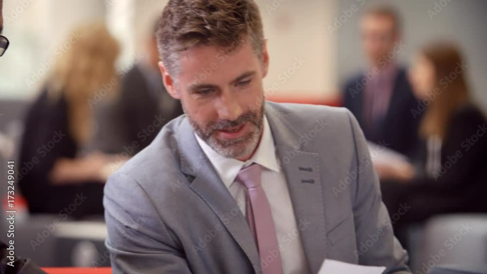 Businesspeople Meeting In Busy Lobby Of Modern Office Businesspeople Meeting In Busy Lobby Of Modern Office