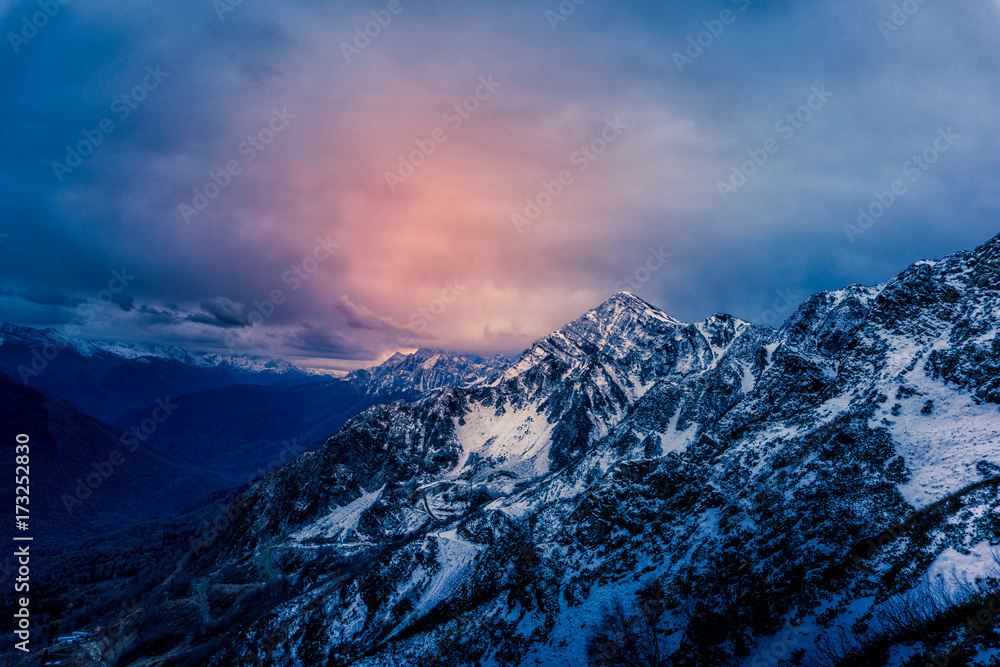 View to the snowy mountains with a dramatic clouded sky