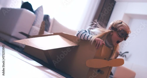 CINEMAGRAPH - seamless loop. Cute dreamer girl child playing in a cardboard airplane. Childhood. Fantasy, imagination concept. 4K UHD