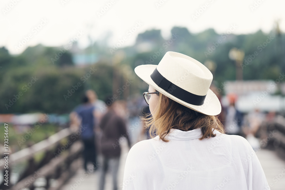 Asian women between the ages of 25-30 years, golden hair standing in a white hat in the middle of the bridge.