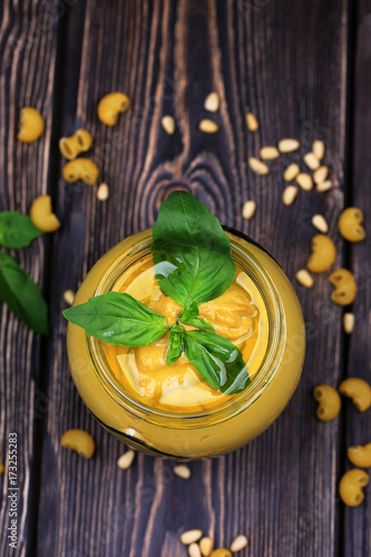 Fototapeta Naklejka Na Ścianę i Meble -  Pesto sauce for pasta on a dark wooden background. Cedar nuts, basil, garlic, olive oil, cheese