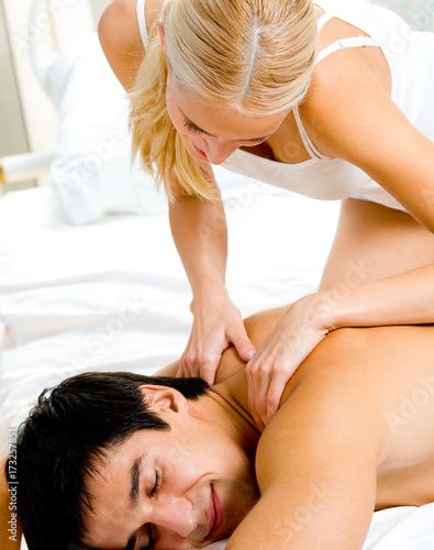 Cheerful young couple making massage at home