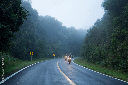 Motorcycle on foggy road in mystery land
